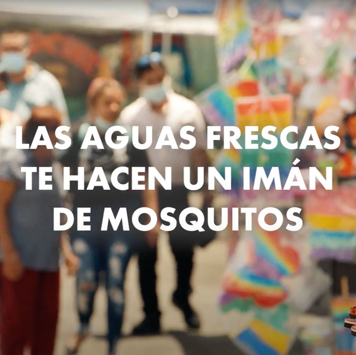 Text: Las aguas frescas te hacen iman de mosquitos over background image of people shopping for pinatas.